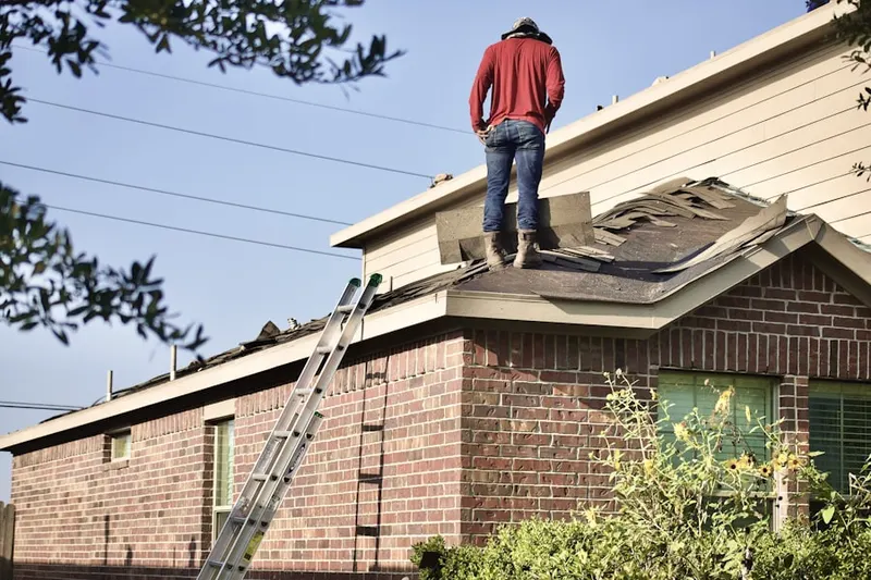 Professional roofer working on a residential roof in Oakland Forest